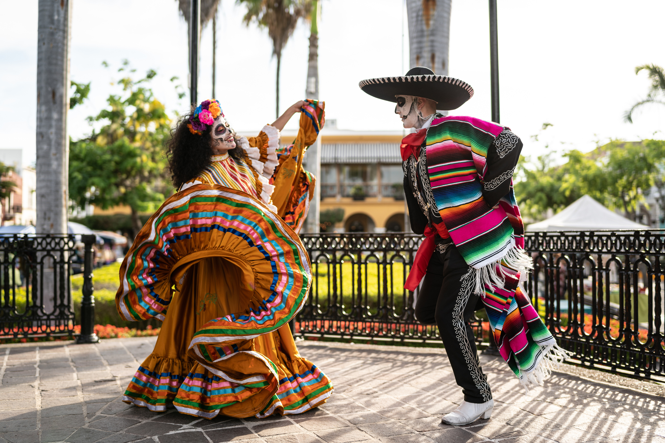 Couple dancing and celebrating the day of the dead with makeup and traditional clothing