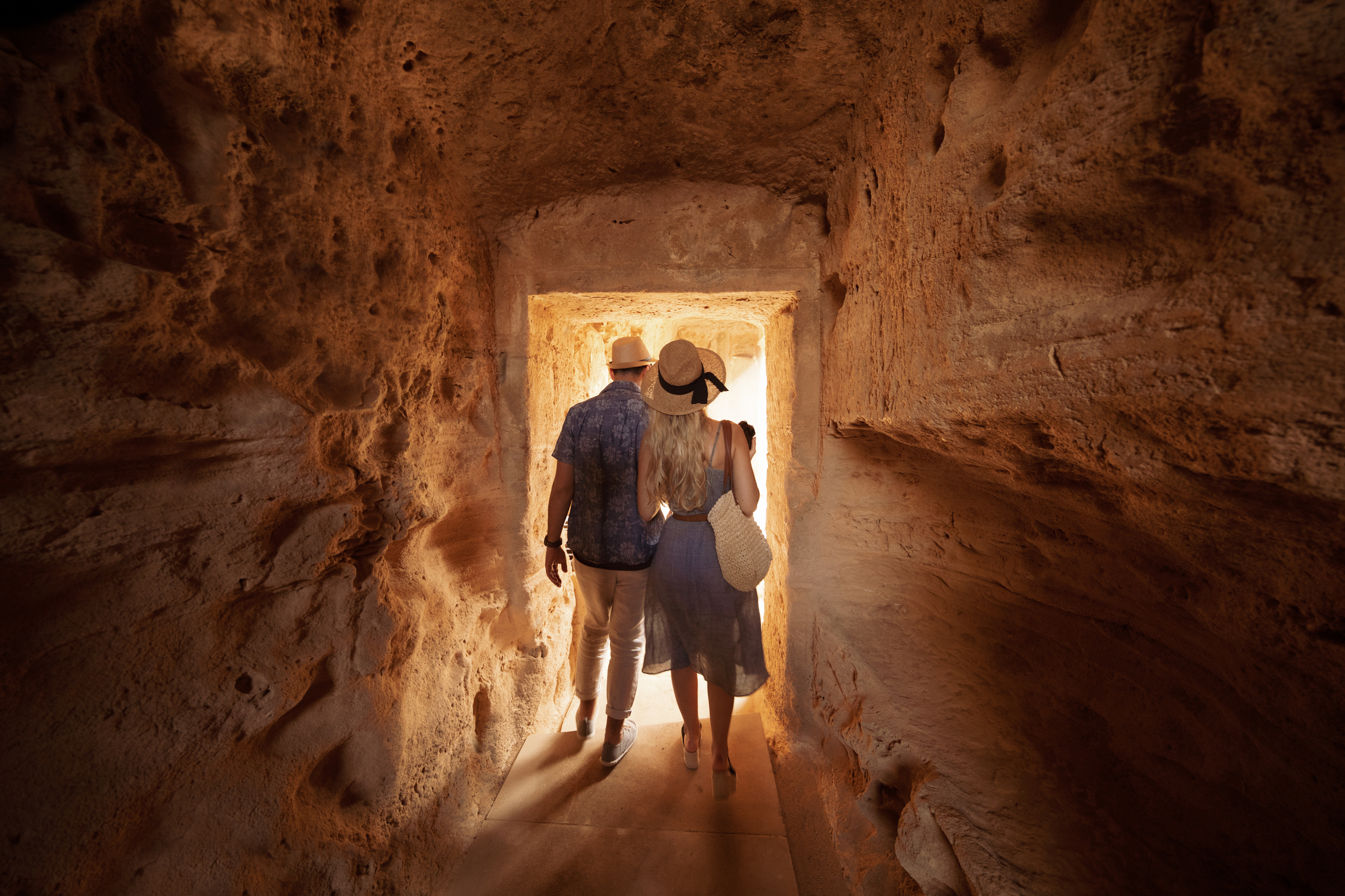 Tourists walking in tunnel and doing sightseeing at ancient archaeological tombs site in Italy