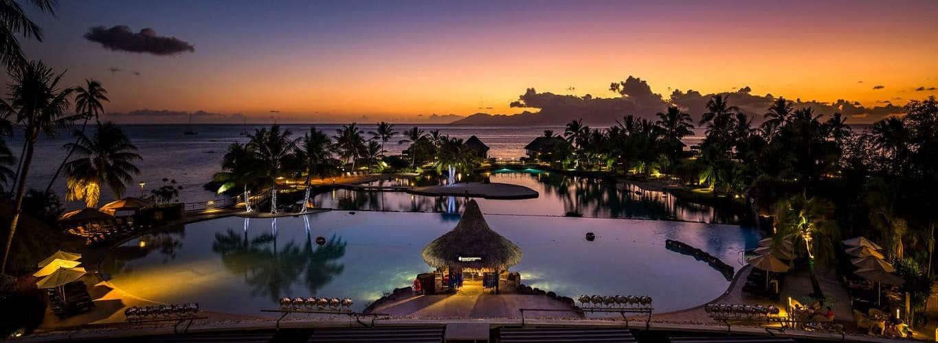 Sunset over swimming pool and tropical beach