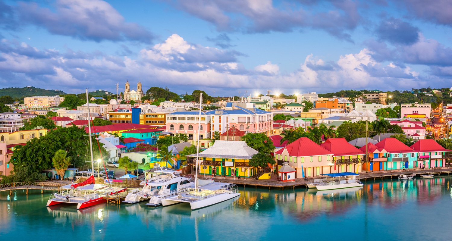 Colorful buildings and white catamaran surrounding harbor