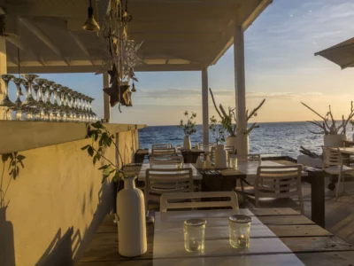 beach bar, glow of sunset shining on chairs, tables, glasses