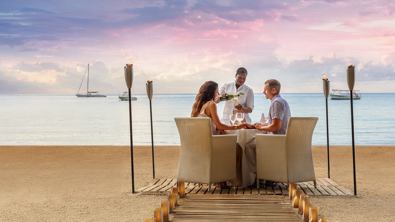 couple dining on the beach of a clothing optional resort