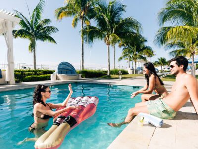 a man and two women lounging in the pool